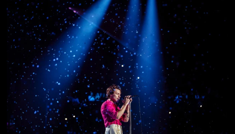 Harry Styles singing at Fine Line Live is wearing Gucci in pink and white.