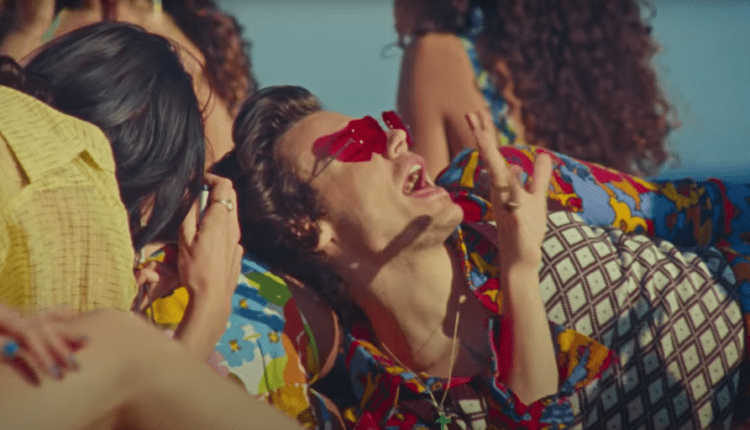 A still of Harry wearing red heart shaped sunglasses in the Watermelon Sugar video