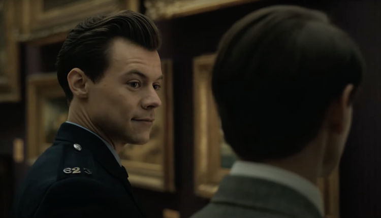 Harry styles is seen looking at david dawson with a light smirk on his face, they are in an art gallery