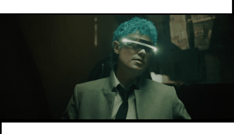 Nick Wold in body language music video, wearing futurisitc glasses, black tie & gray jacket